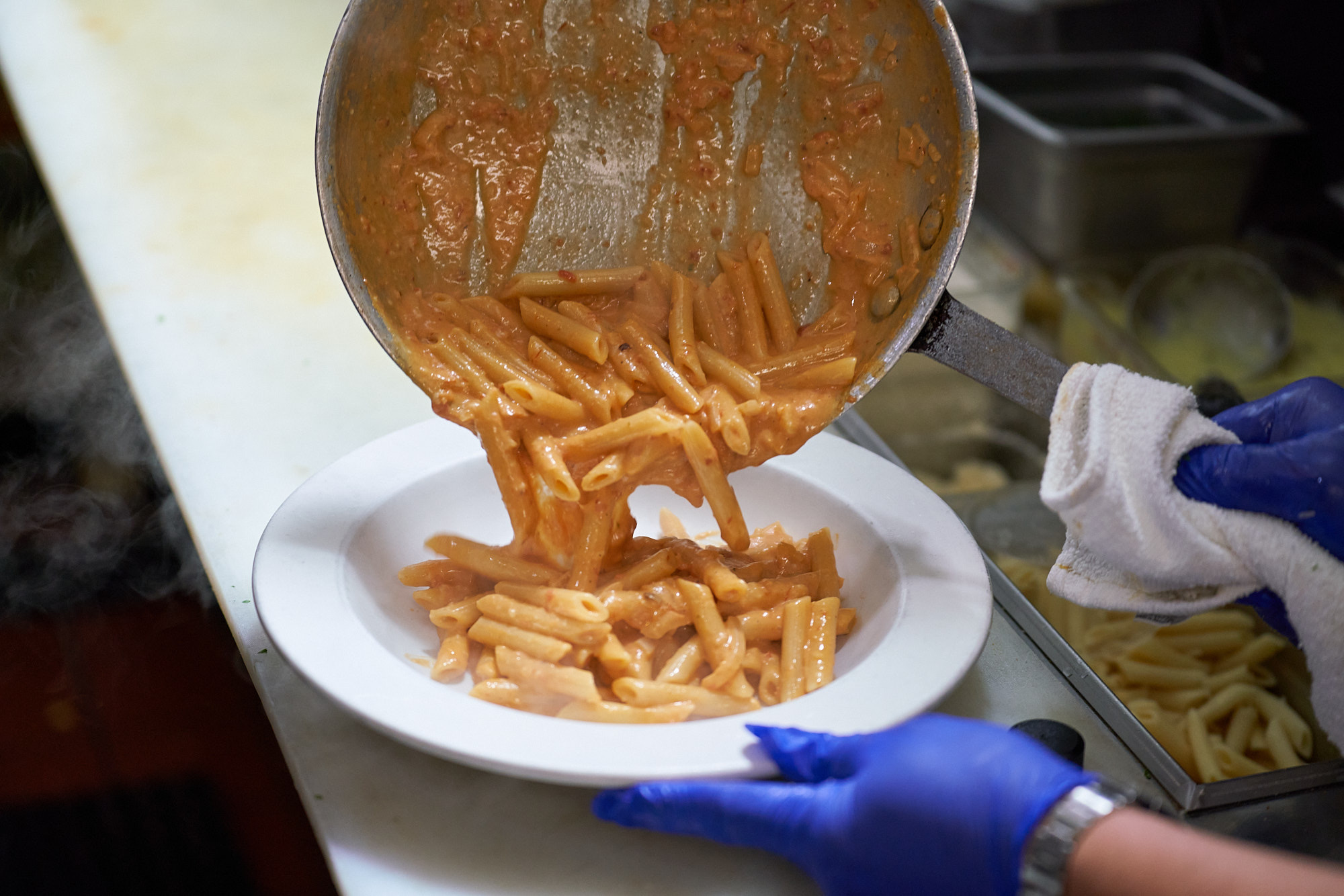 Fresh pasta being plated in the Rico's kitchen